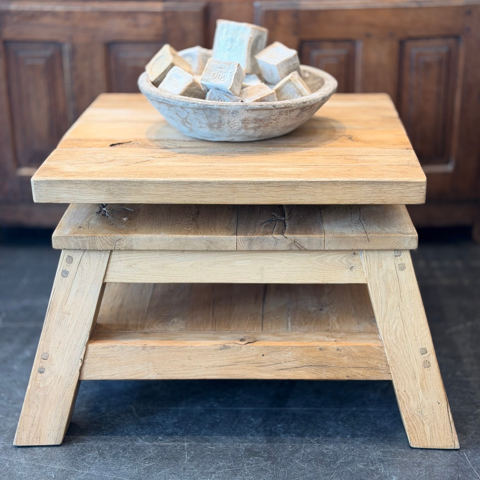Wooden step stool with a bowl of wooden blocks on top against a wooden panel background
