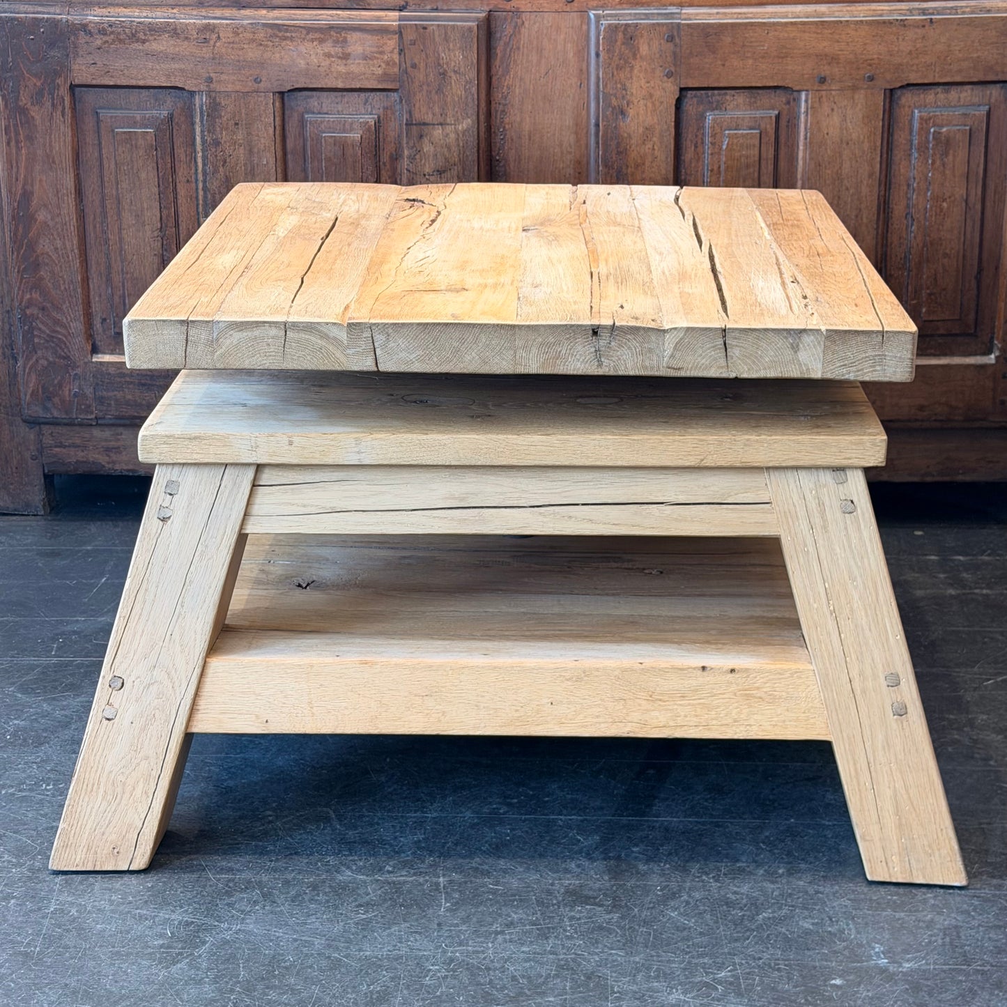 Wooden step stool with a rustic design against a wooden panel background