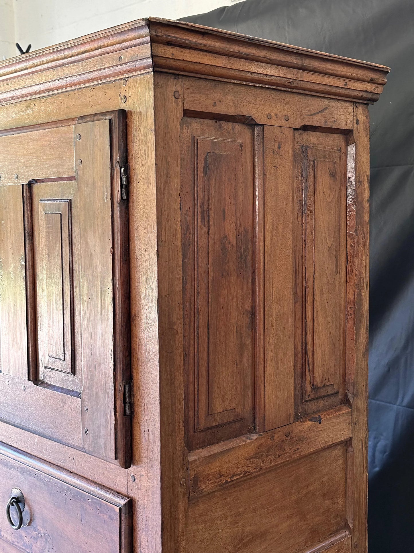 Wooden cabinet with panelled doors and a visible hinge.